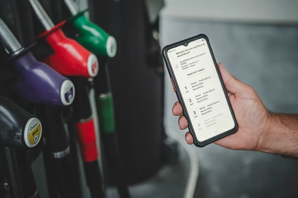 Hand hält Smartphone mit Kostner Smart App – Zapfsäulenauswahl an Station Varna mit Diesel, HVO und Benzin