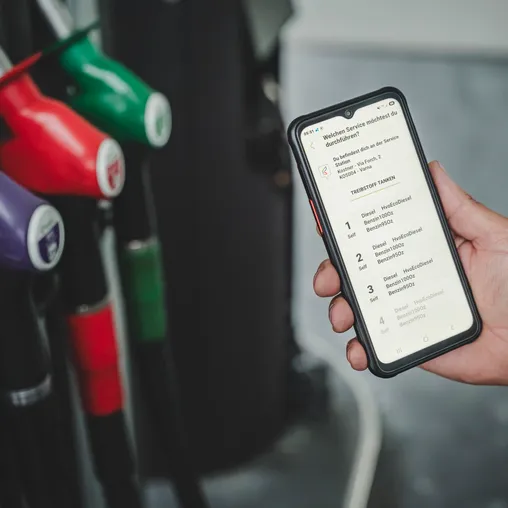 Hand hält Smartphone mit Kostner Smart App – Zapfsäulenauswahl an Station Varna mit Diesel, HVO und Benzin
